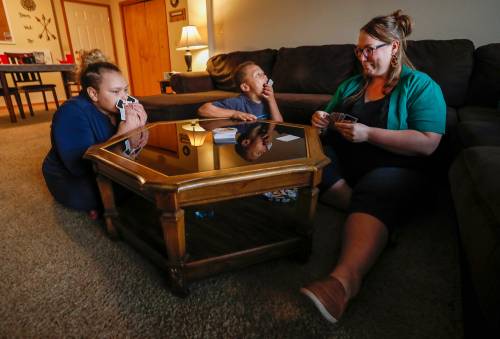 Kristina Hazeltine plays a game of Uno Dare with her children A.J. Wilson, 12, left, and Deacon Hazeltine, 6, center, at their home on Monday, Sept. 16, 2019, in Springfield, Mo.Hazeltine5