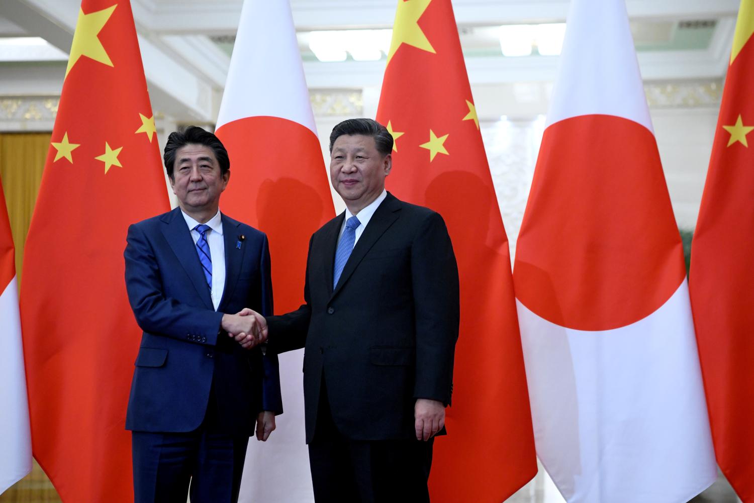 Japan's Prime Minister Shinzo Abe shakes hands with China's President Xi Jinping at the Great Hall of the People in Beijing, China, December 23, 2019. Noel Celis/Pool via REUTERS