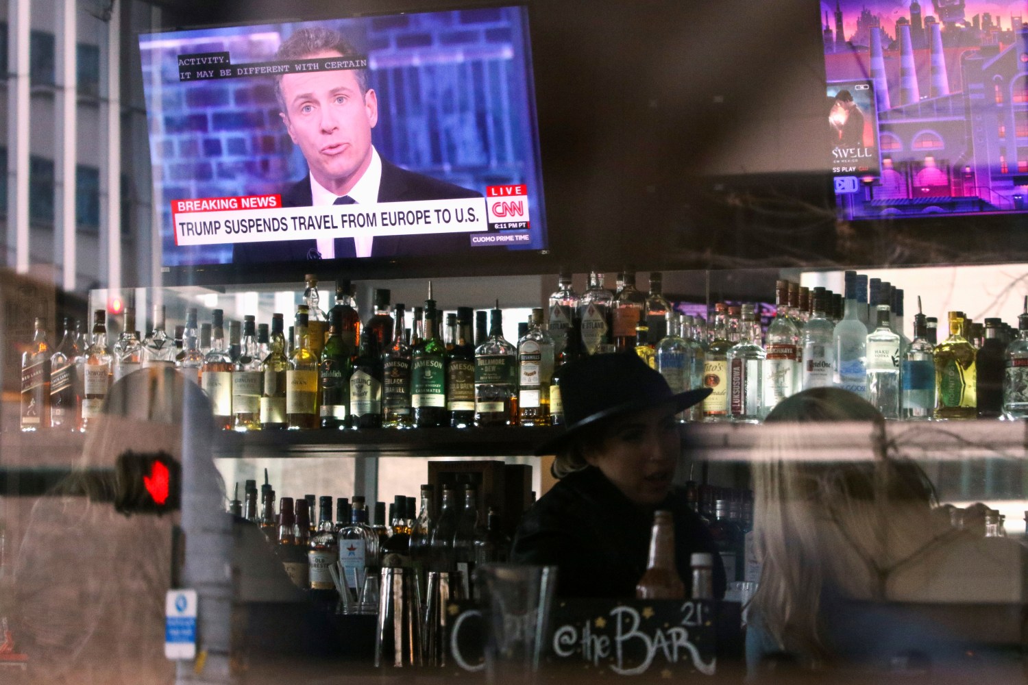 A CNN headline reading "Trump Suspends Travel From Europe to U.S." is pictured on the television in the bar at A Pizza Mart, in Seattle, Washington, U.S. March 11, 2020. REUTERS/Jason Redmond