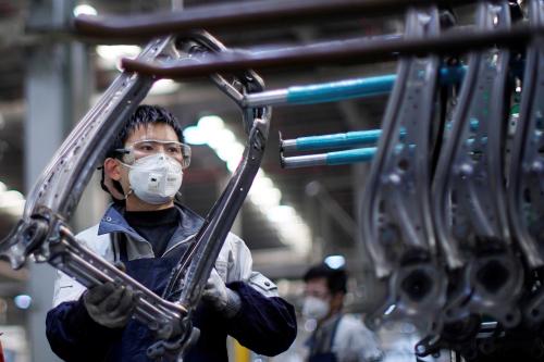 An employee wearing a face mask works on a car seat assembly line at Yanfeng Adient factory in Shanghai, China, as the country is hit by an outbreak of a new coronavirus, February 24, 2020. REUTERS/Aly Song