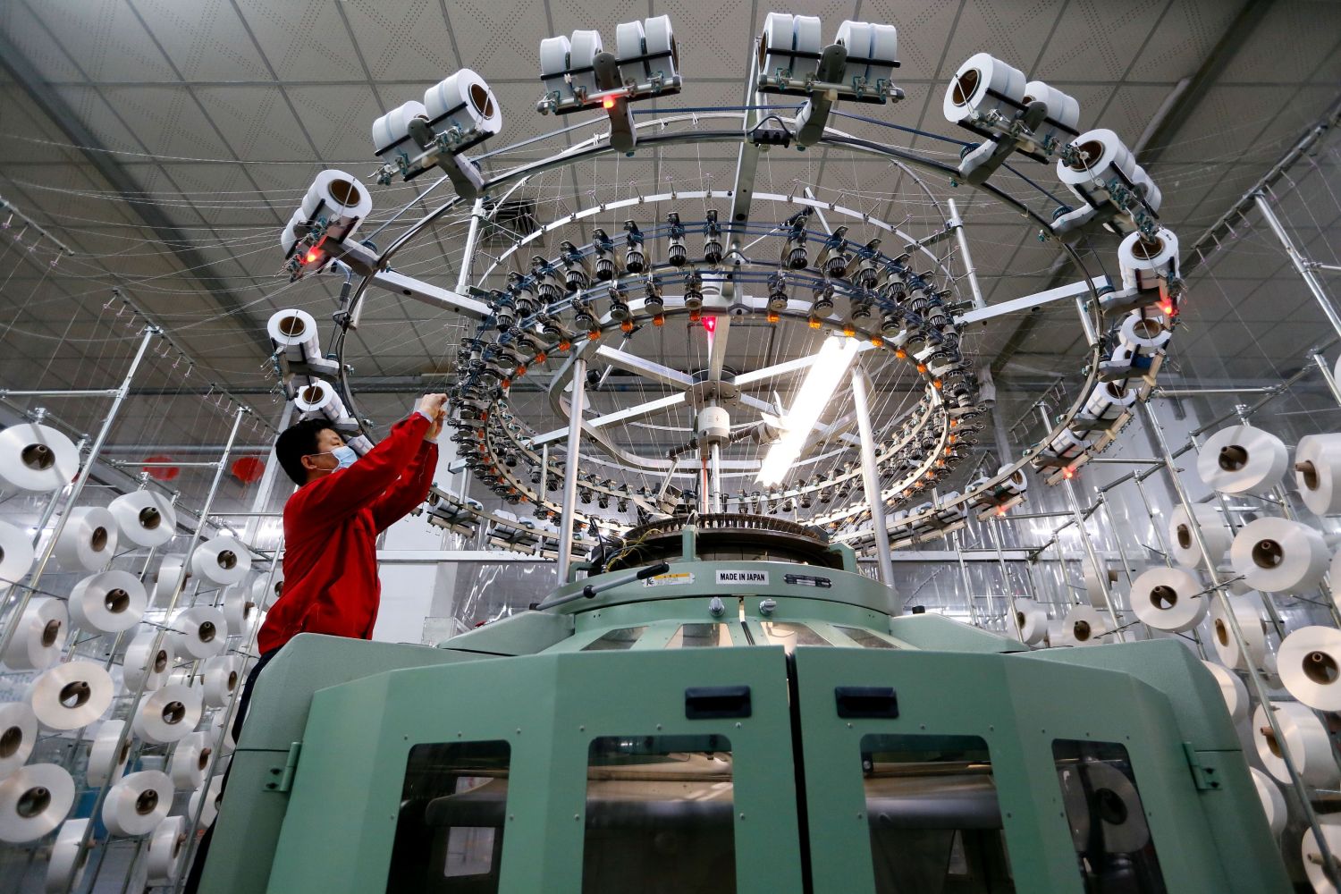 A textile worker is seen on a fabric production line at a factory in Qingdao, Shandong province, China February 14, 2020. China Daily via REUTERS  ATTENTION EDITORS - THIS IMAGE WAS PROVIDED BY A THIRD PARTY. CHINA OUT.