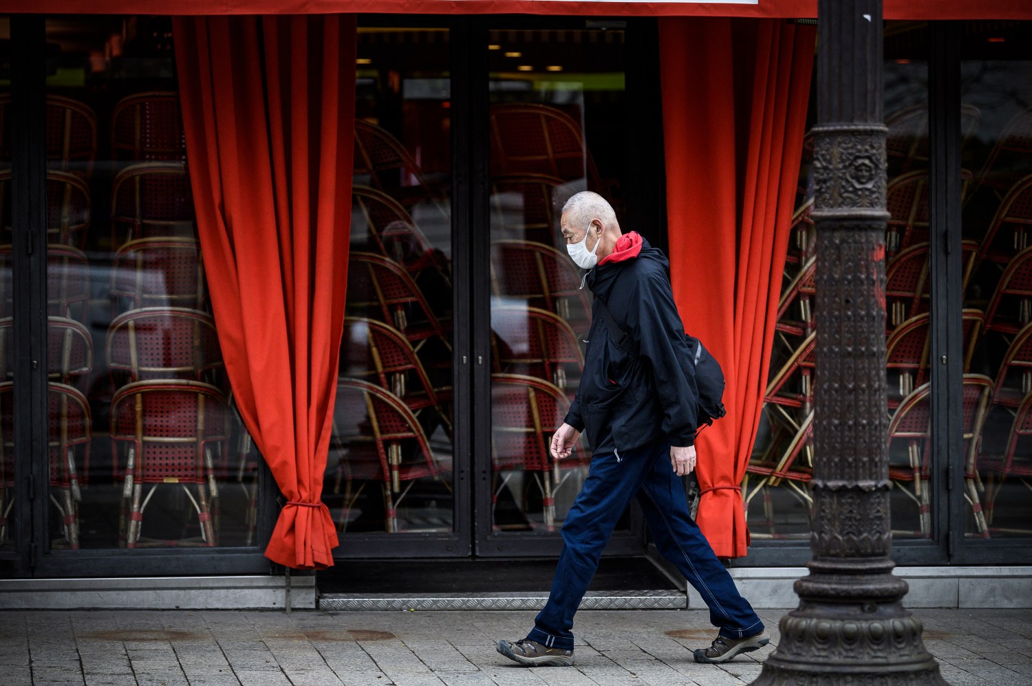 A man wearing a protective face mask in front of a restaurant in Paris (Avenue des Champs Elysee) as shops, schools remain closed and workers asked to work from home if possible, part of the latest French governmental measures against the coronavirus disease (COVID-19) outbreak, France, March 16, 2020.Photo by Eliot Blondet/ABACAPRESS.COM