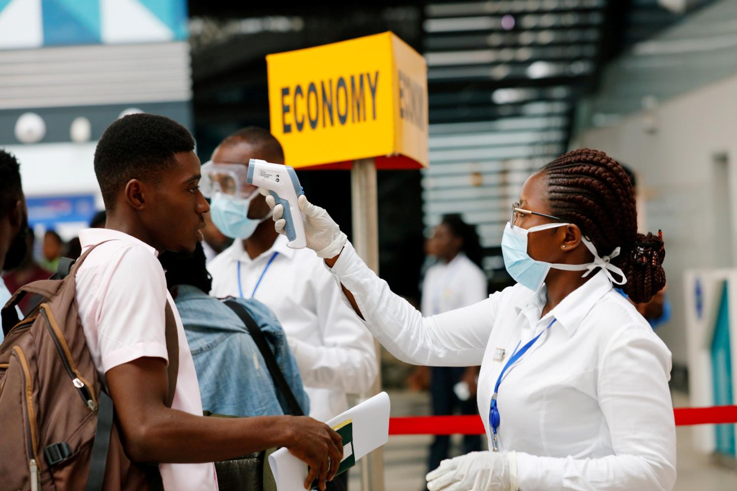 FILE PHOTO: A health worker checks the temperature of a traveller as part of the coronavirus screening procedure at the Kotoka International Airport in Accra, Ghana January 30, 2020. REUTERS/Francis Kokoroko/File Photo