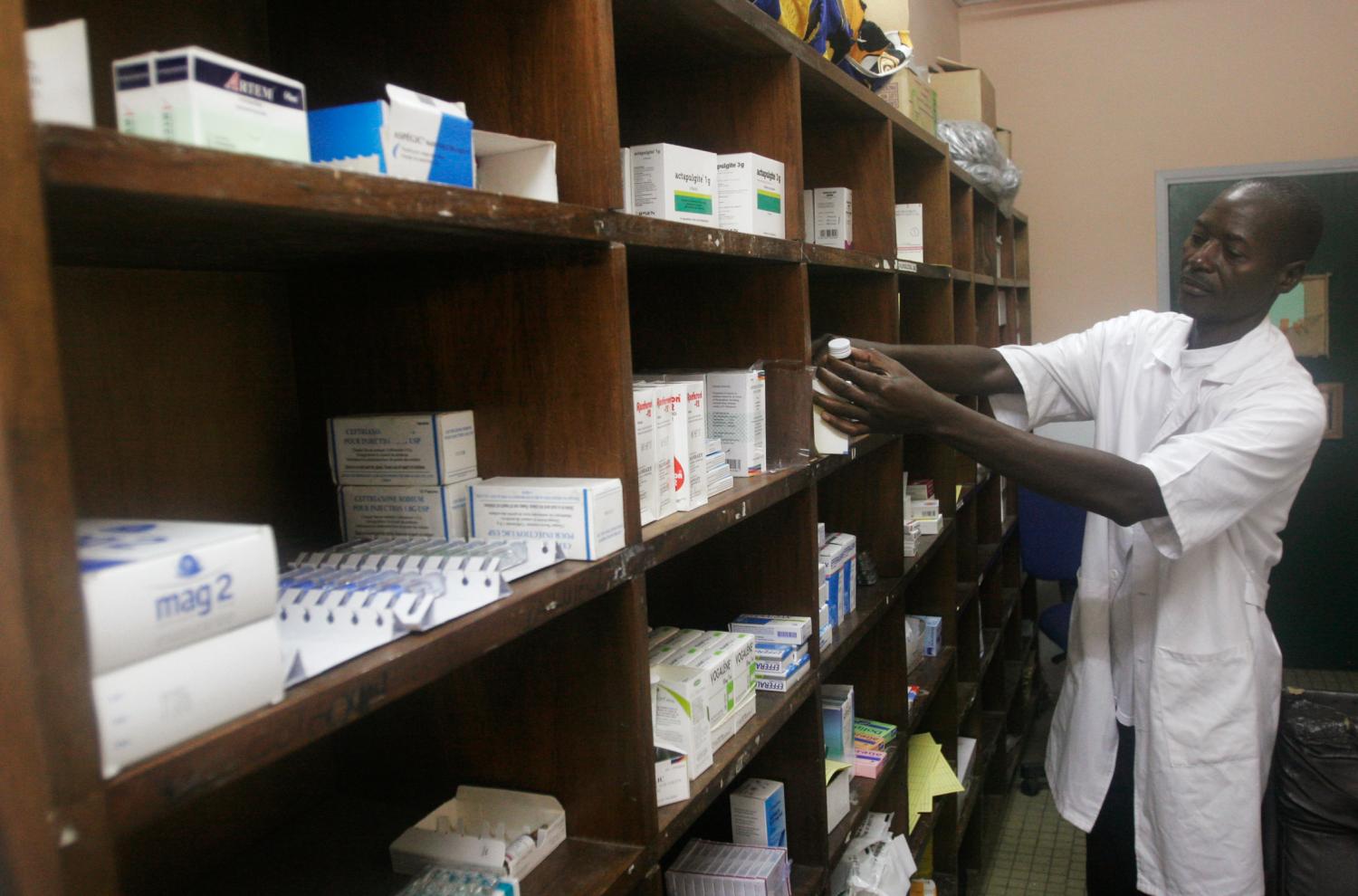 An employee looks for medicine at a hospital pharmacy in Abidjan April 8, 2011. Days of clashes between forces loyal to presidential claimant Alassane Ouattara and incumbent Laurent Gbagbo, who refuses to cede power, have turned what was once known as the "Paris of Africa" into a ghost city. Aid agencies say hospitals are overwhelmed with wounded, medical supplies are lacking and doctors and nurses sometimes have to work without running water and electricity.  REUTERS/ Thierry Gouegnon (IVORY COAST - Tags: HEALTH CIVIL UNREST POLITICS)