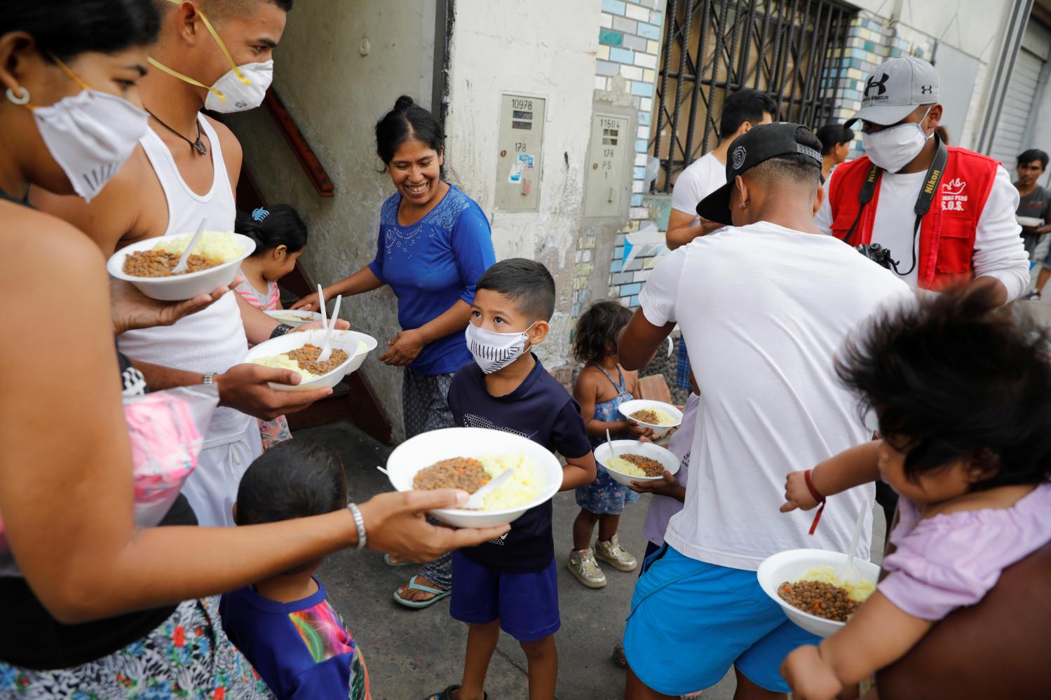 Haitians who are homeless and stranded in the country and Venezuelan immigrants receive food aid from the church during the quarantine and mandatory immobilization as the spreading of the coronavirus disease (COVID-19) continues, in Lima, Peru March 30, 2020. REUTERS/Sebastian Castaneda NO RESALES. NO ARCHIVES