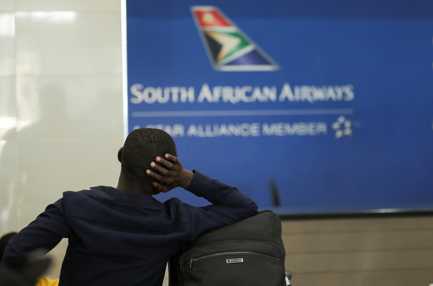 A passenger is seen at the South African Airways (SAA) customer desk, after SAA announced that it would immediately suspend all intercontinental flights until May 31 in response to a government travel ban aimed at stopping the spread of the coronavirus disease (COVID-19), at the O.R. Tambo International Airport in Johannesburg, South Africa March 20, 2020. REUTERS/Siphiwe Sibeko