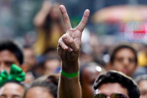 A man holds up a peace sign in a crowd while watching performers at the Brazilian Day 2017 festival in New York City, U.S., September 3, 2017. REUTERS/Joe Penney