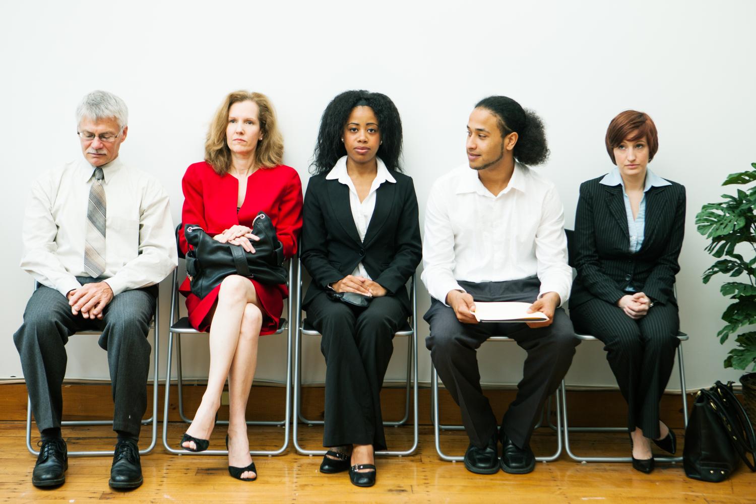 A diverse group of people sitting in a waiting room.