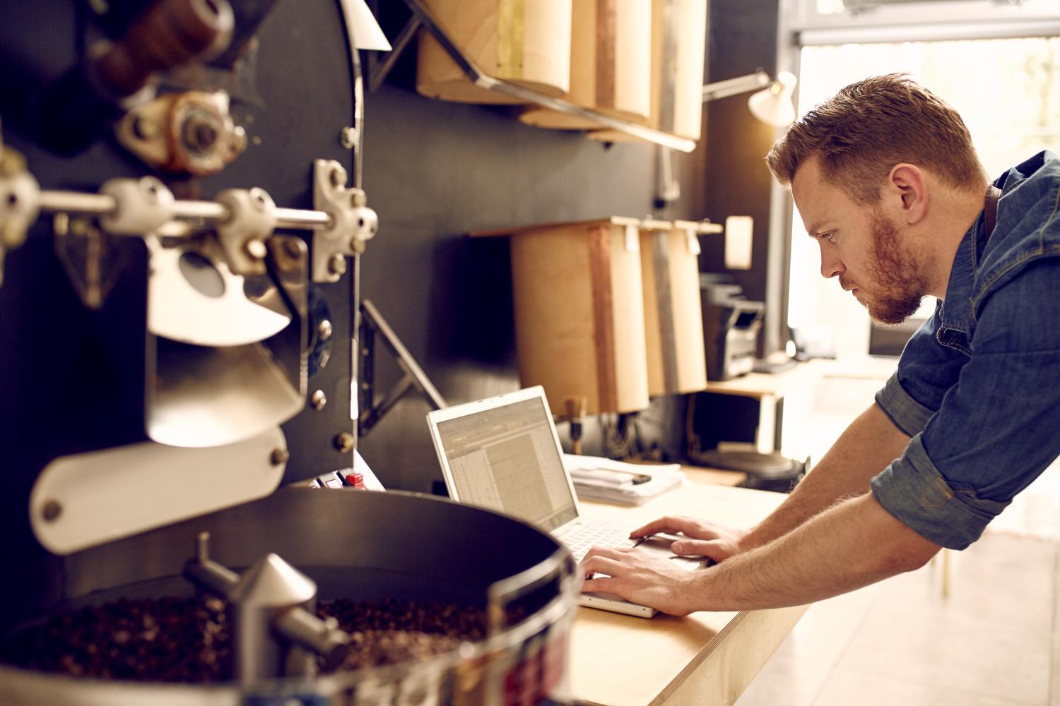 Business owner of a coffee roastery checking his laptop