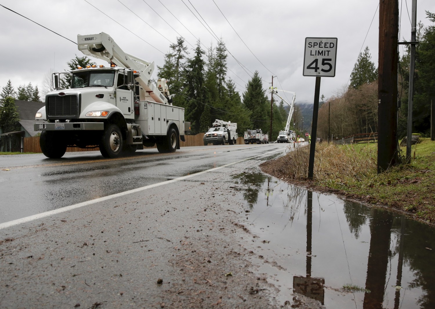 Utility trucks are pictured along Issaquah-Hobart Road Southeast as crews work to restore power lines in Issaquah, Washington December 10, 2015. Residents of the U.S. Pacific Northwest were hit by fresh storms on Thursday after the region received record-breaking rainfall that left two dead in Oregon and triggered widespread flooding, landslides, road closures and power cuts. REUTERS/Jason Redmond