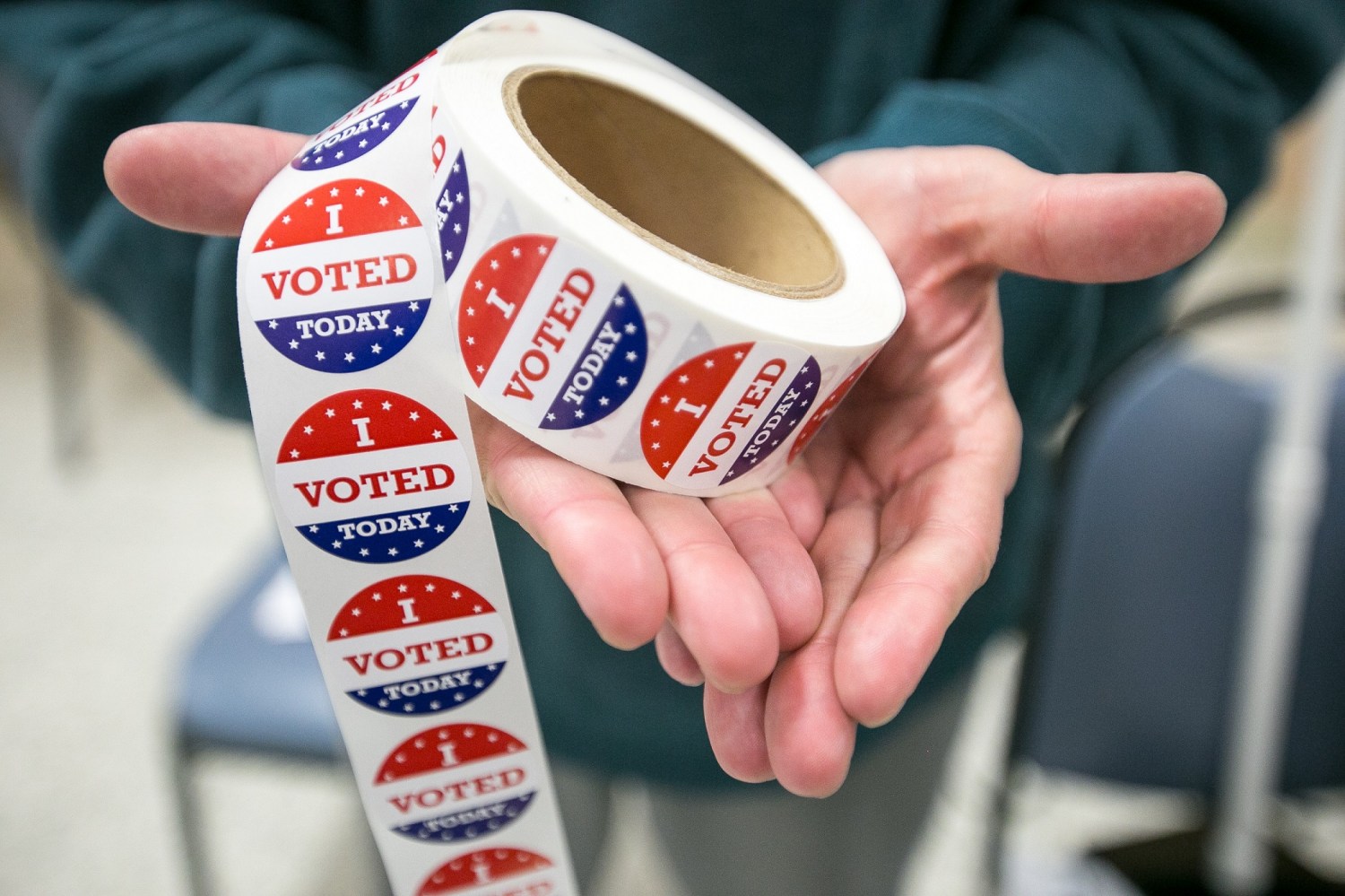 Mar 17, 2020; Rockford, IL, USA;  First time election judge Steve Ateca holds a spool of voting stickers next to the ballot box at St. Bernadette Catholic Church in Rockford, Ill., Tuesday, March 17, 2020. Mandatory Credit: Scott P. Yates/Rockford Register Star via USA TODAY NETWORK
