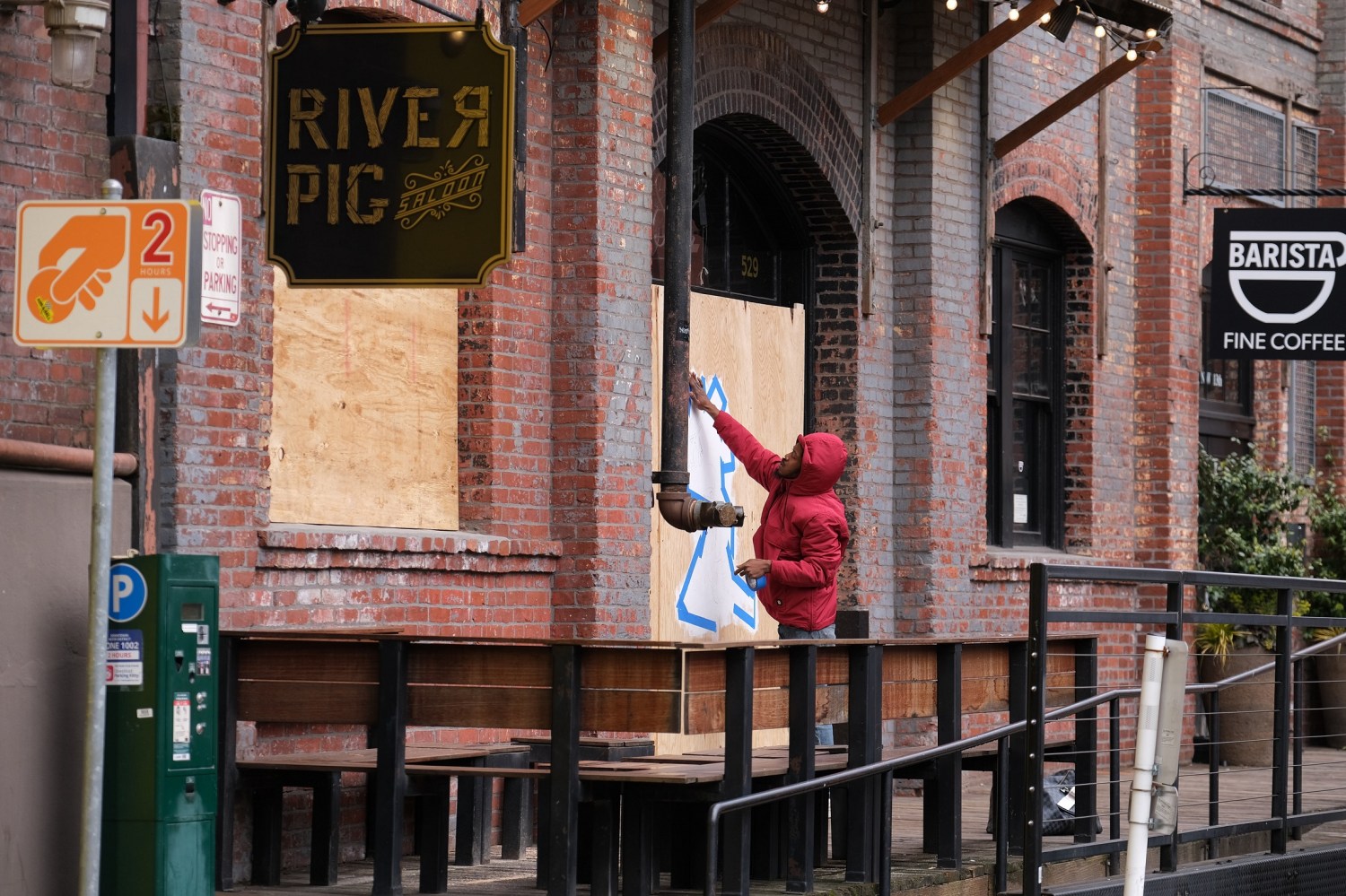An artist works on a boarded up River Pig Saloon in Portland, Ore., on March 24, 2020. Yesterday Governor Kate Brown issued a statewide executive order to stay home except for essential needs as more extreme social distancing measures aim to slow the spread of the novel coronavirus (COVID-19) and flatten the curve. (Photo by Alex Milan Tracy/Sipa USA)No Use UK. No Use Germany.