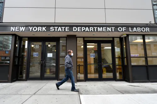 Surge in US unemployment claims cuases Governemnt servers to crash. A man wearing a protective mask walks past the New York State Department of Labor offices in the New York City borough of Brooklyn, NY, March 25, 2020. Anthony Behar/Sipa USA)No Use UK. No Use Germany.