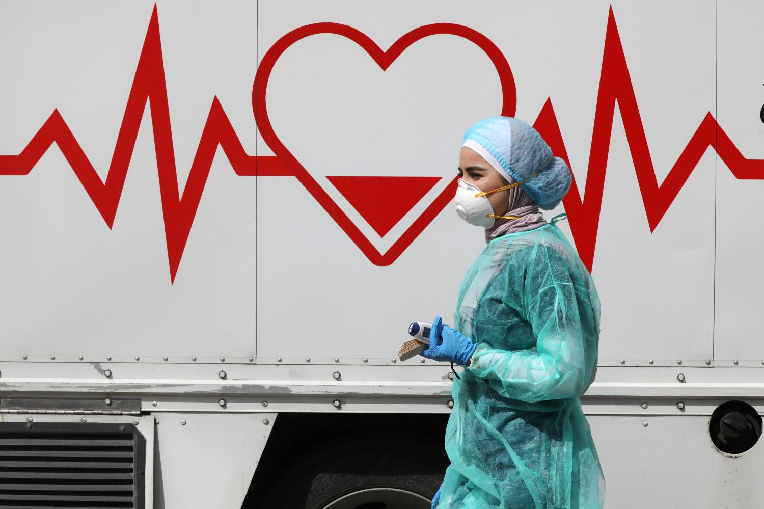 A Jordanian doctor walks next a mobile clinic that is operated as part of initiative that was launched with the aim of providing Jordanians with field medical services, amid concerns over the spread of the coronavirus disease (COVID-19), in Amman, Jordan, March 30, 2020. Picture taken March 30, 2020. REUTERS/Muhammad Hamed