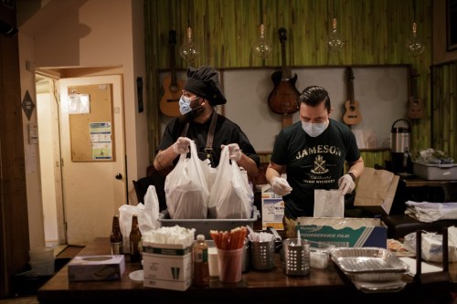 Chef Jorge Cardenas, 41, (left) and Ix employee Daniel Gonzalez, 34, pack takeout orders in the final hour before the restaraunt's closure in the Brooklyn borough of New York City, U.S., April 2, 2020 amid the coronavirus disease (COVID-19) outbreak. Picture taken April 2, 2020. REUTERS/Anna Watts