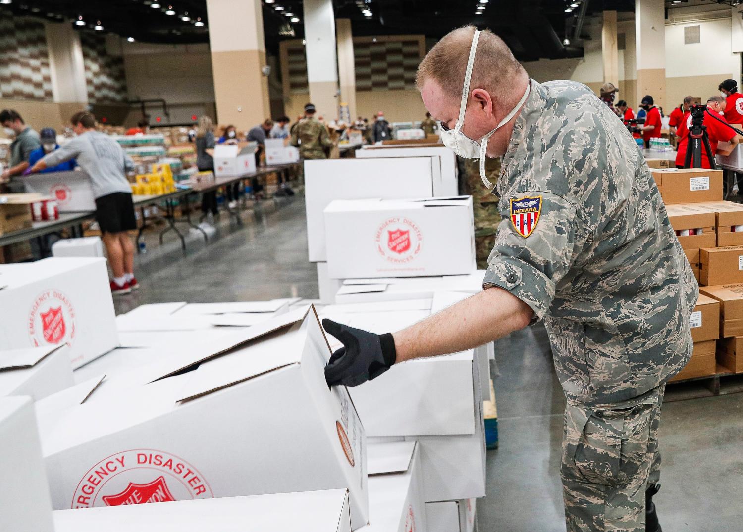 Indiana National Guard Second Lt. Joseph Parnin picks up empty boxes at Lucas Oil Stadium, Indianapolis, Friday, April 17, 2020. The food boxes will be filled with shelf-stable items designed to help supplement the pantries of families who are struggling due to COVID-19 shut-downs.Ini Meals