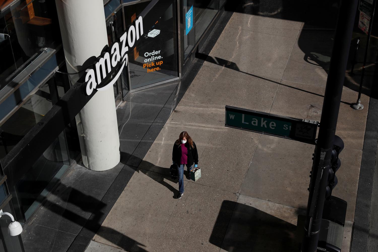 A woman wearing a face mask walks past a closed Amazon store as the spread of the coronavirus disease (COVID-19) continues, in Chicago, Illinois, U.S., April 20, 2020.  REUTERS/Shannon Stapleton