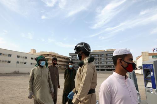 A police officer wears a smart helmet as he uses it to test the temperature of workers during the outbreak of the coronavirus disease (COVID-19) in Dubai, United Arab Emirates April 23, 2020. REUTERS/Ahmed Jadallah