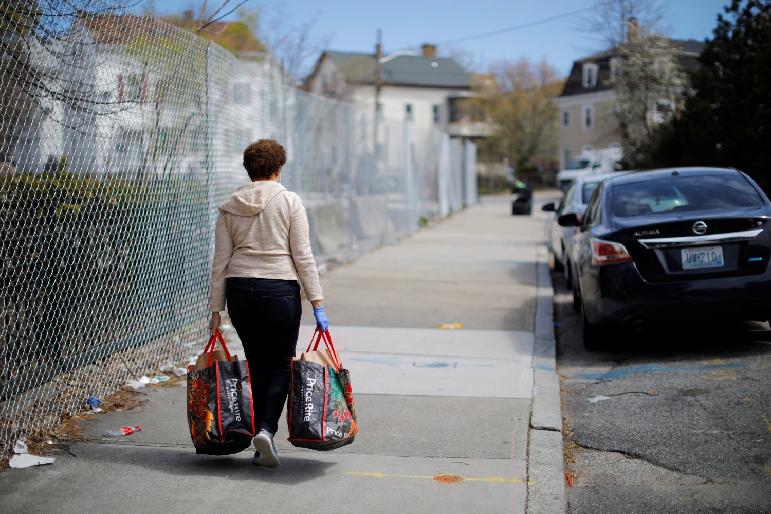 A woman carries her free groceries from the PICA Olneyville Food Center amid the coronavirus disease (COVID-19) outbreak in Providence, Rhode Island, U.S., April 23, 2020.   REUTERS/Brian Snyder