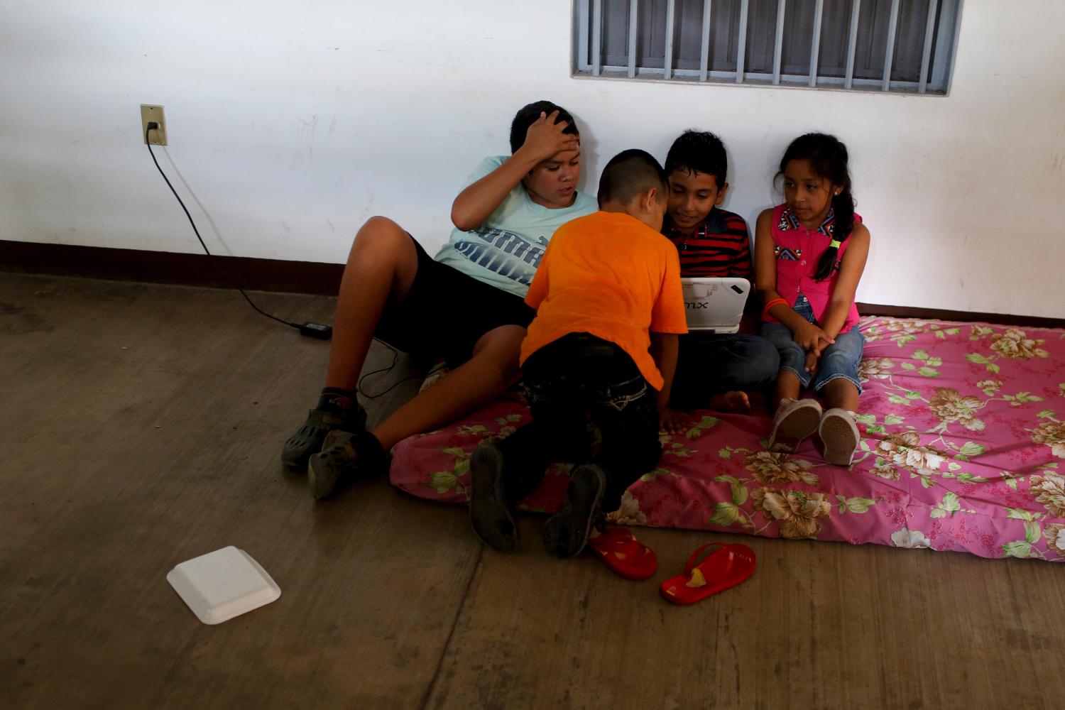 Children watch a movie on a computer at a shelter in the town of Comala, in the Mexican state of Colima, October 24, 2015. Hurricane Patricia caused less damage than feared on Mexico's Pacific coast on Saturday, but hammered an isolated part of the shoreline dotted with luxury villas and fishing villages, where the storm and its 165 mph (266 kph) winds landed. Thousands of residents and tourists fled the advance of the storm, one of the strongest in recorded history, seeking refuge in hastily arranged shelters. REUTERS/Tomas Bravo