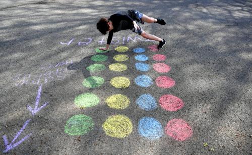 Franklin's Forrest Crossing neighborhood has created a  "Social Distancing Calendar of Fun."   On Wednesday, some residents like Eli Ecken,11, plays Twister during neighborhood's chalk walk Franklin on  April 1, 2020.Sem 1233