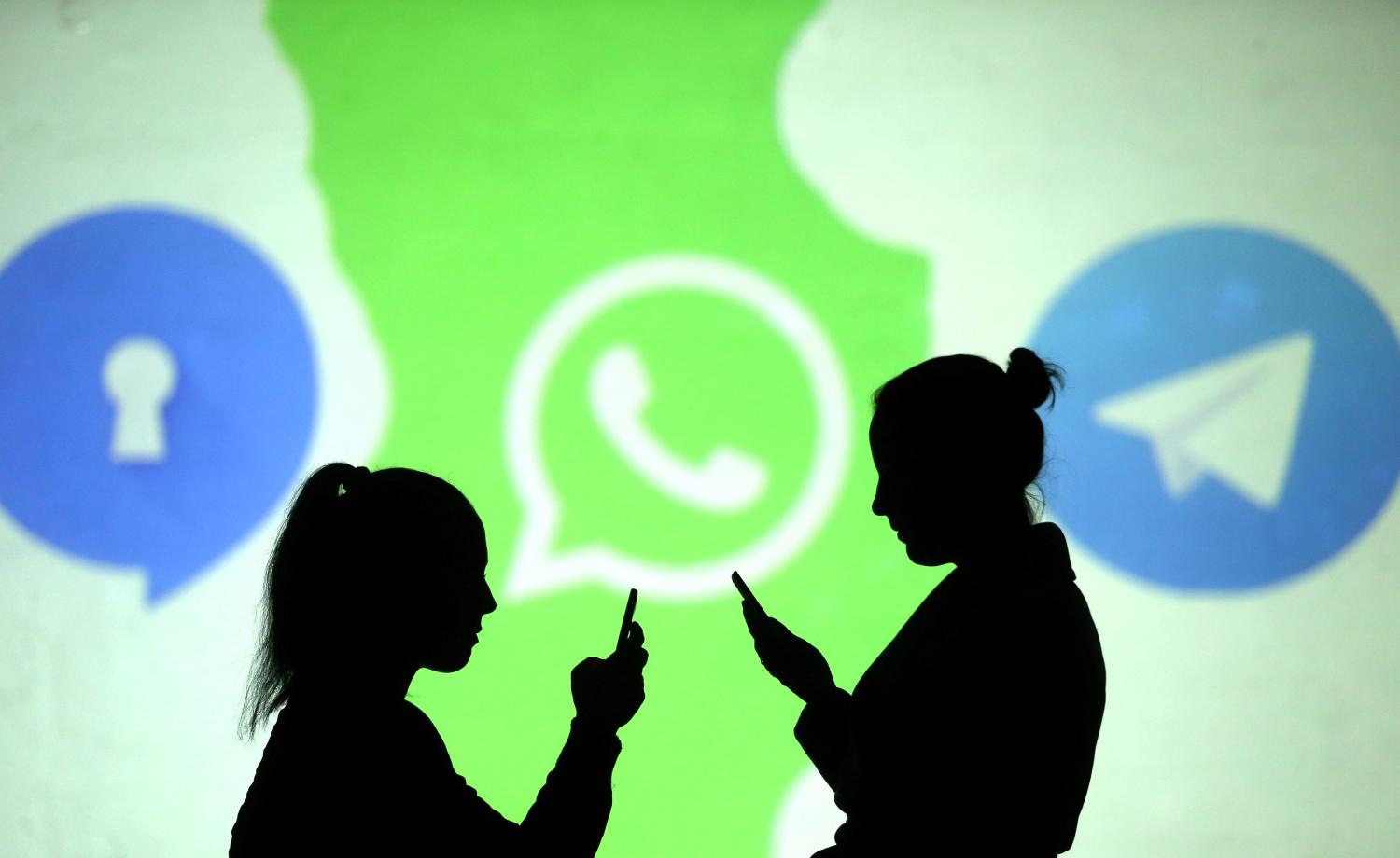 Silhouettes of mobile users are seen next to logos of social media apps Signal, Whatsapp and Telegram projected on a screen in this picture illustration taken March 28, 2018.  REUTERS/Dado Ruvic/Illustration