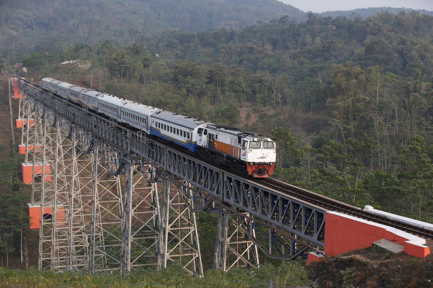 A passenger train crosses the Chikubang bridge as it travels from the city of Bandung to Jakarta near Padalarang, West Java, Indonesia August 25, 2015. Japan's prime minister has sent an envoy to Indonesia to offer a sweeter deal to build a high-speed railway, a Japanese embassy official said on Thursday, highlighting the importance of the multi-billion dollar project that China also wants to win. The two Asian giants are in a neck-and-neck contest to win a contract to build Indonesia's first high-speed rail, between the capital Jakarta and textile hub Bandung, a project that would bolster their influence in Southeast Asia's biggest economy.Picture taken August 25, 2015. REUTERS/Darren Whiteside