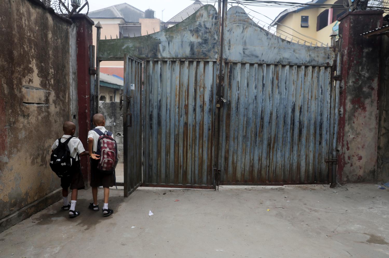 Sons of Onyeka Oguaghamba, one of the Nigerian men arrested on charges of public display of affection with members of the same sex, walk to school in Lagos, Nigeria, February 11, 2020. Oguaghamba says he was sleeping outside the hotel in car at the time of the raid and was caught up in the arrests. While he was in police detention, Oguaghamba said, his four boys were told their father had been on television. "I felt so bad, although they didn't understand what gay means," he said. "They asked me - why police arrested me and they were showing me on television. I explained to them that the police can arrest anybody at any time." REUTERS/Temilade Adelaja    SEARCH "NIGERIA LGBT" FOR THIS STORY. SEARCH "WIDER IMAGE" FOR ALL STORIES.