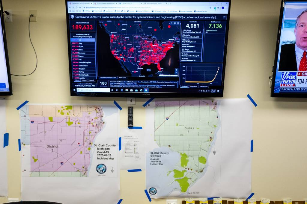 A screen displaying statistics of the spread of coronavirus is hung on the wall above different maps in St. Clair County's emergency operation center Wednesday, April 1, 2020.20200401 Emergency Operation Center Coronavirus 0006