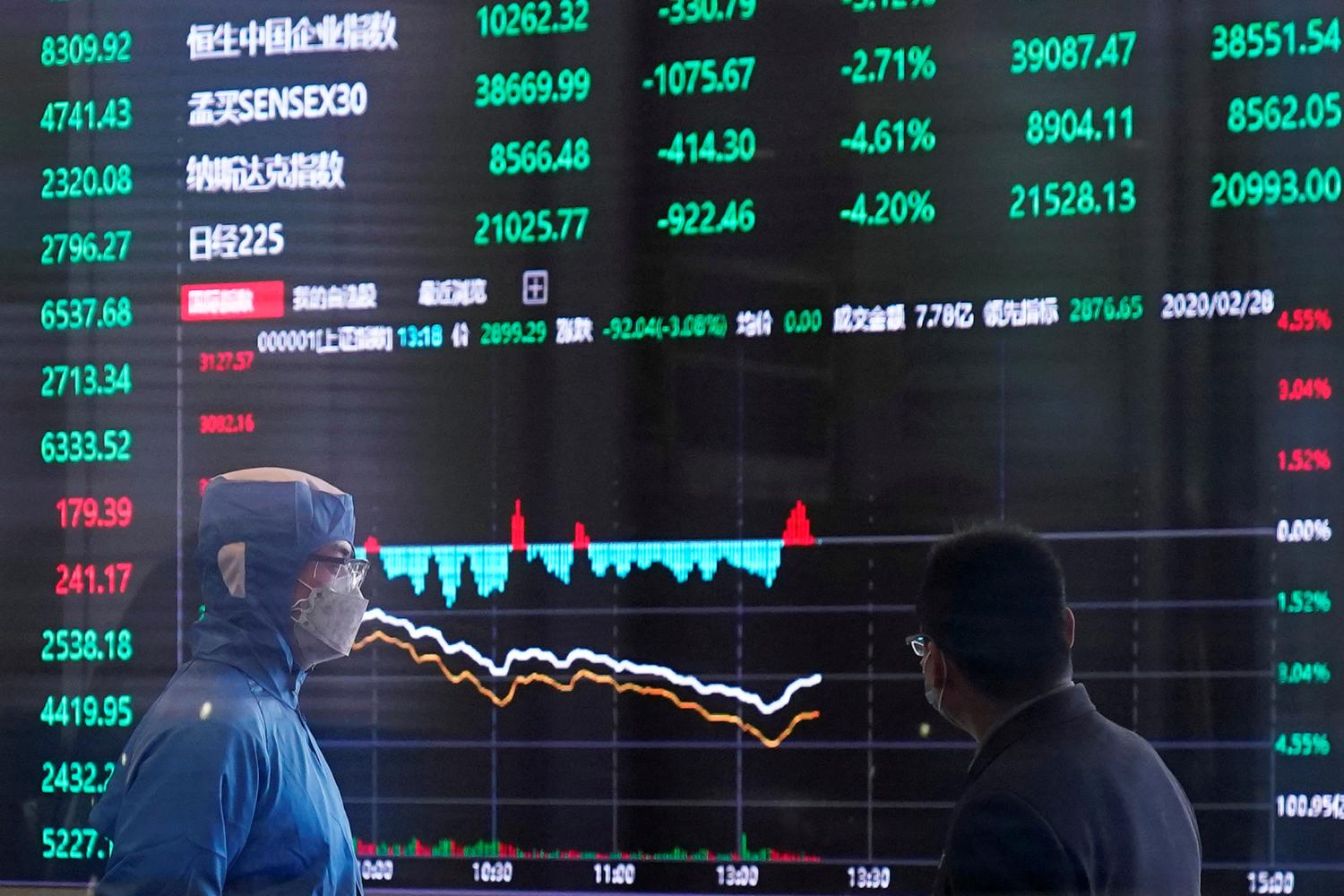 FILE PHOTO: A worker wearing a protective suit is seen inside the Shanghai Stock Exchange building amid the coronavirus outbreak, at the Pudong financial district in Shanghai, China February 28, 2020. REUTERS/Aly Song/File Photo