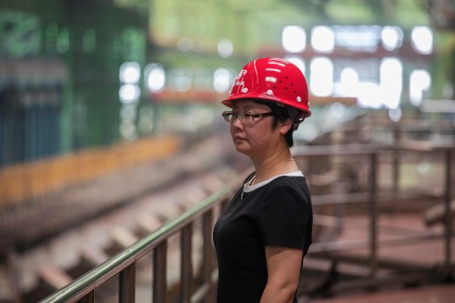 A woman looks on at the Chongqing Iron and Steel plant in Changshou, Chongqing, China August 6, 2018. Picture taken August 6, 2018. REUTERS/Damir Sagolj