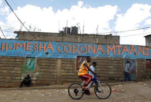 A man cycles past a wall mural advocating against the coronavirus disease (COVID-19) outbreak in Nairobi, Kenya April 11, 2020. REUTERS/Njeri Mwangi