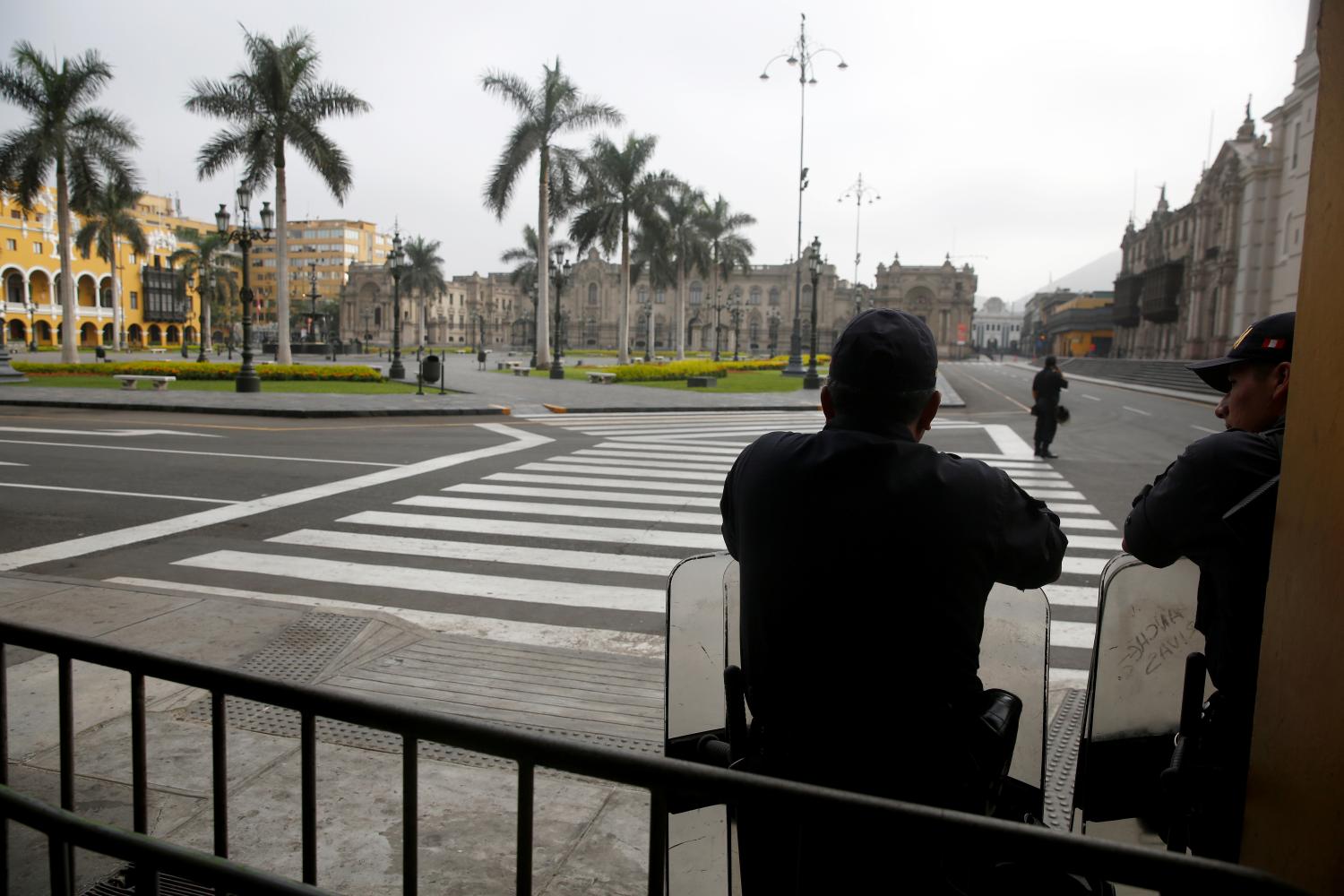 Police officers guard an empty Plaza de Armas after Peru's government deployed military personnel to block major roads, as the country rolled out a 15-day state of emergency to slow the spread of coronavirus disease (COVID-19), in Lima, Peru March 16, 2020. REUTERS/Sebastian Castaneda NO RESALES. NO ARCHIVES