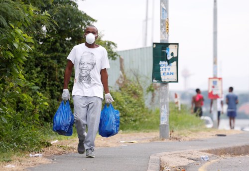 A man carries home groceries during a nationwide 21 day lockdown in an attempt to contain the coronavirus disease (COVID-19) outbreak in Umlazi township near Durban, South Africa, March 31, 2020. REUTERS/Rogan Ward