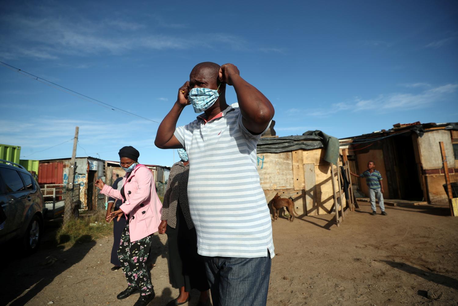 Community volunteers put the masks on as they prepare to distribute food packages during a 21-day nationwide lockdown aimed at limiting the spread of the coronavirus disease (COVID-19) in a township in Cape Town, South Africa, April 17, 2020. REUTERS/Mike Hutchings