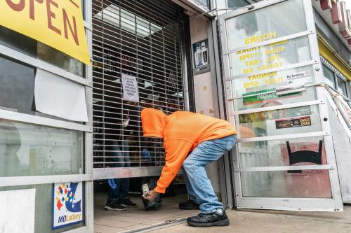 A man hands money to a shopkeeper through a gate to help slow the spread of coronavirus disease (COVID-19) at a mini-mart in north St. Louis, Missouri, U.S. April 4, 2020. Picture taken April 4, 2020.  REUTERS/Lawrence Bryant