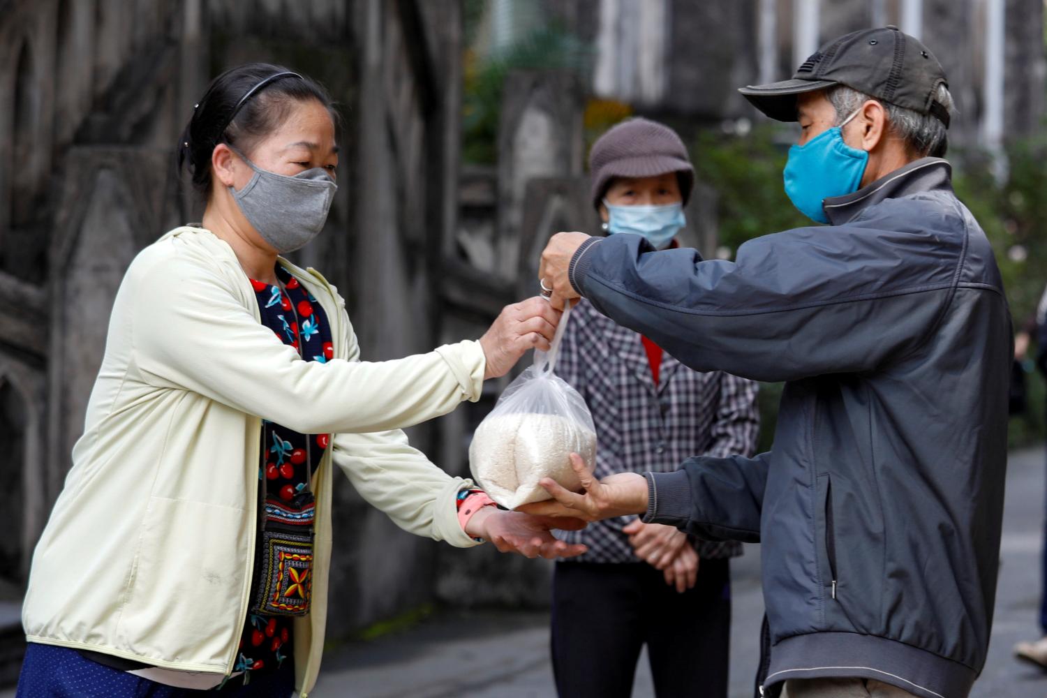 People receive rice donation in front of Saint Joseph Cathedral during the coronavirus disease (COVID-19) outbreak in Hanoi, Vietnam April 27, 2020. REUTERS/Kham