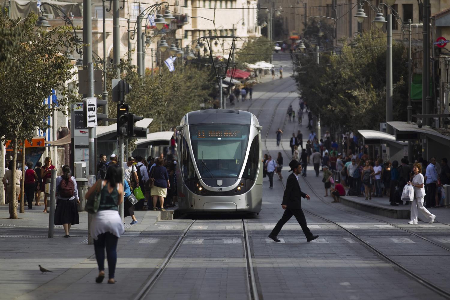 People walk near the light rail in the centre of Jerusalem October 18, 2015. A surge in Palestinian attacks in Israel is raising concerns that the weakening economy could eventually be pushed into recession. Picture taken October 18, 2015. REUTERS/Amir Cohen