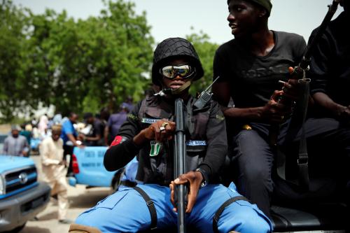 A member of the local militia, otherwise known as CJTF, Baba Gana, holds a gun as he sits in the back of a truck during a patrol in the city of Maiduguri, northern Nigeria June 9, 2017. Picture taken June 9, 2017. REUTERS/Akintunde Akinleye.