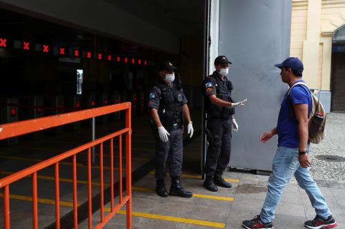 Police officers wearing protective face masks stop a passenger to check his documents before entering the ferry station to go to Niteroi, amid the coronavirus disease (COVID-19) outbreak, in Rio de Janeiro, Brazil March 22, 2020. REUTERS/Pilar Olivares