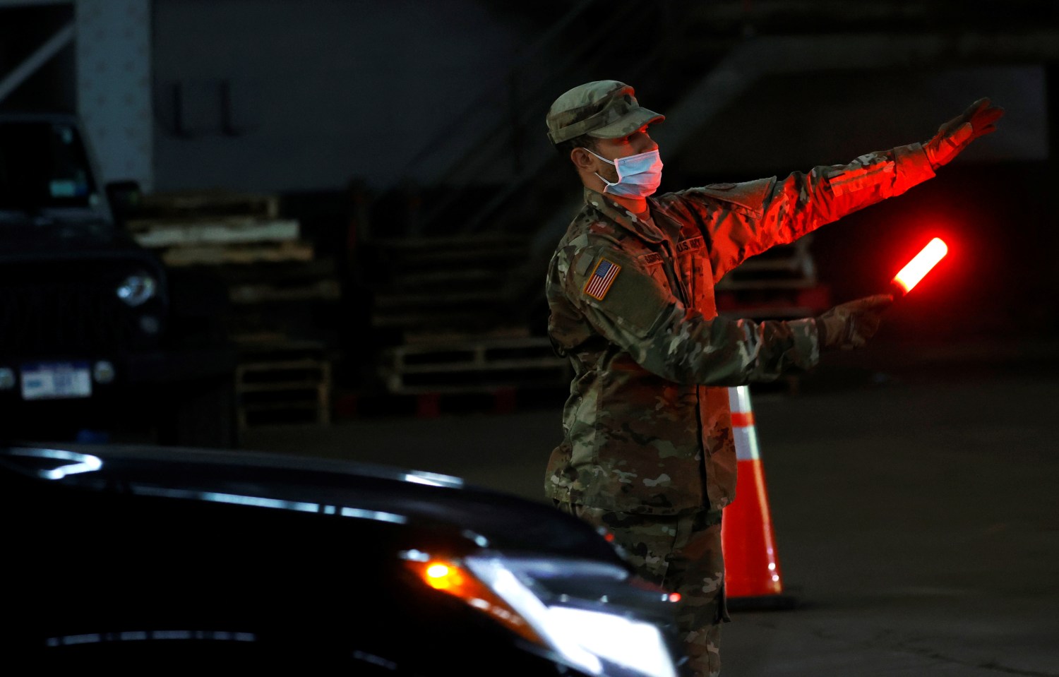 A U.S. Army National Guard soldier wears a protective face mask while directing vehicles to pick up food for delivery to residents in need, at the Kingsbridge Armory which is being used as a temporary food distribution center during the outbreak of the coronavirus disease (COVID-19) in the Bronx borough of New York City, New York, U.S., April 21, 2020. REUTERS/Mike Segar