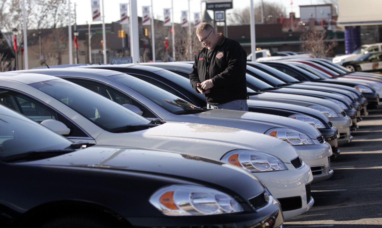 A potential customer looks at a 2009 Chevrolet Impala sedan at a car dealership in Dearborn, Michigan December 29, 2008. General Motors and Chrysler are scheduled to each receive $4 billion of loan money today from the U.S. Treasury Department according to the terms of their agreement.  REUTERS/Rebecca Cook (UNITED STATES)