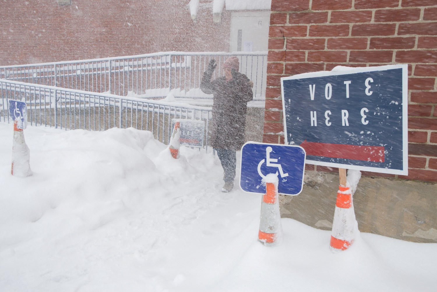 A woman leaves the polling place as winter storm blanketed the state on local election day in Plaistow, New Hampshire, U.S., March 13, 2018. On the orders of state officials, New Hampshire municipalities proceeded with scheduled elections despite a winter storm that covered the region in snow and made driving difficult.  REUTERS/Randall Mikkelsen