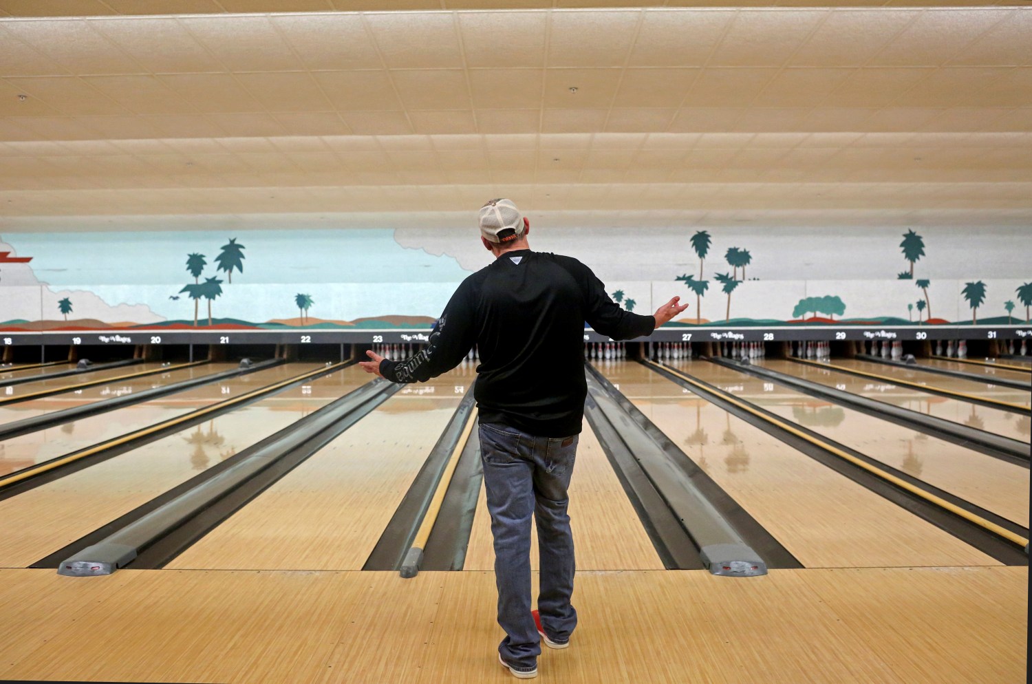 A man bowls in a nearly empty bowling alley inside McCall's Tavern at Spanish Springs Town Square, amid coronavirus (COVID-19) cases in The Villages, Florida, U.S. March 16, 2020.  REUTERS/Yana Paskova