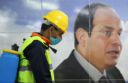 A member of medical team is seen beside a banner for the Egyptian President Abdel Fattah el-Sisi, as he sprays disinfectant as a precautionary move amid concerns over the coronavirus disease (COVID-19) outbreak at the underground Al Shohadaa "Martyrs" metro station in Cairo, Egypt March 22, 2020. REUTERS/Mohamed Abd El Ghany