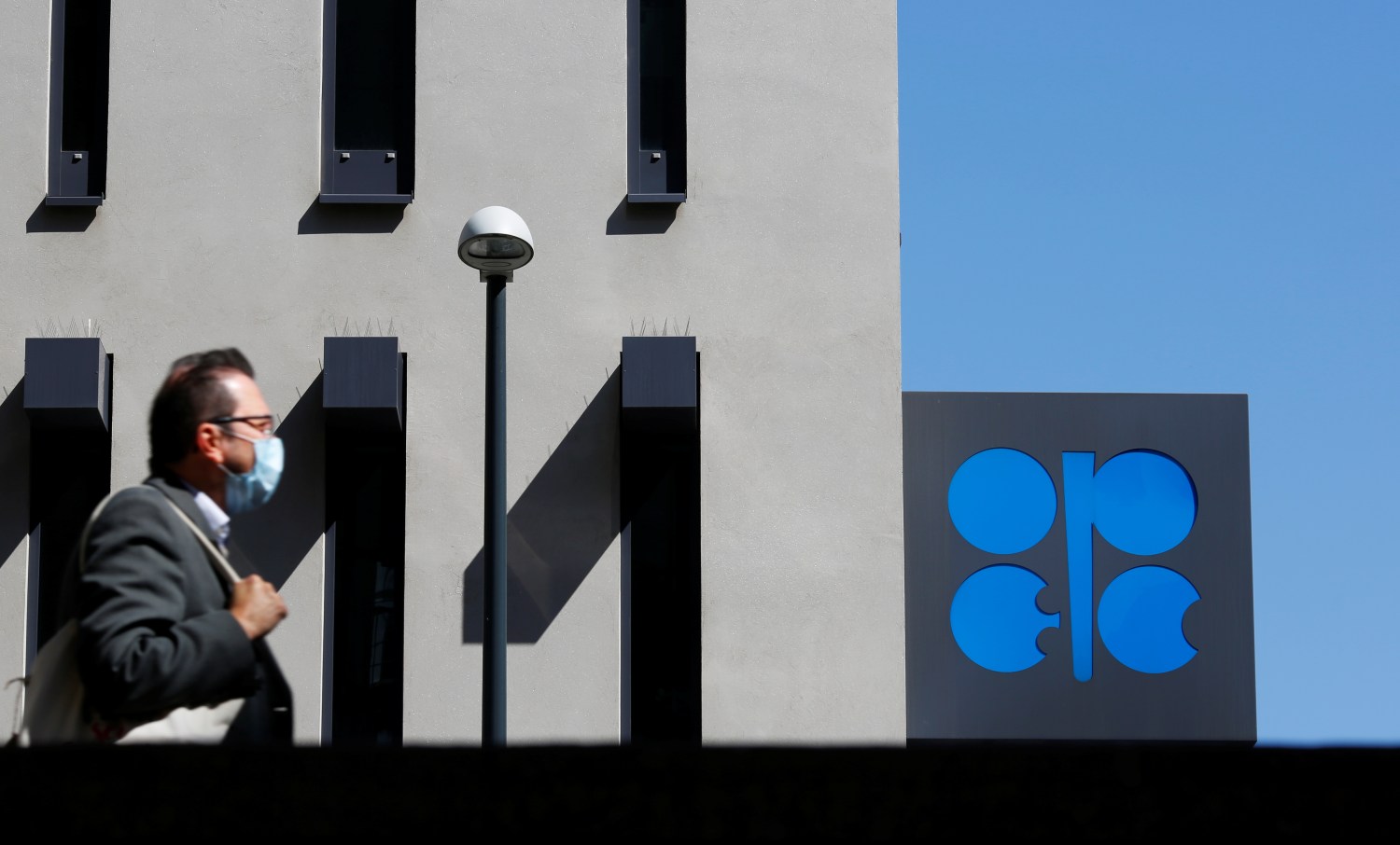 A person passes the logo of the Organization of the Petroleoum Exporting Countries (OPEC) in front of OPEC's headquarters in Vienna, Austria April 9, 2020.  REUTERS/Leonhard Foeger