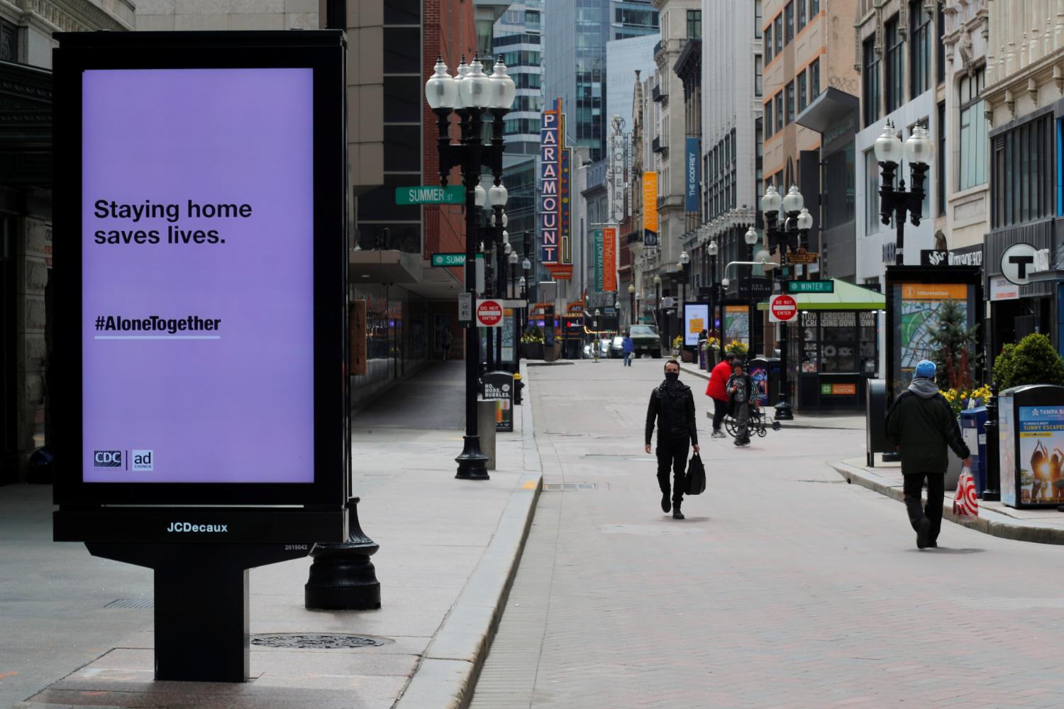 Pedestrians walk through the nearly empty Downtown Crossing shopping area after Massachusetts Governor Charlie Baker extended his stay-at-home advisory and his order closing non-essential businesses until May 18 because of the coronavirus disease (COVID-19) outbreak in Boston, Massachusetts, U.S., April 28, 2020.   REUTERS/Brian Snyder