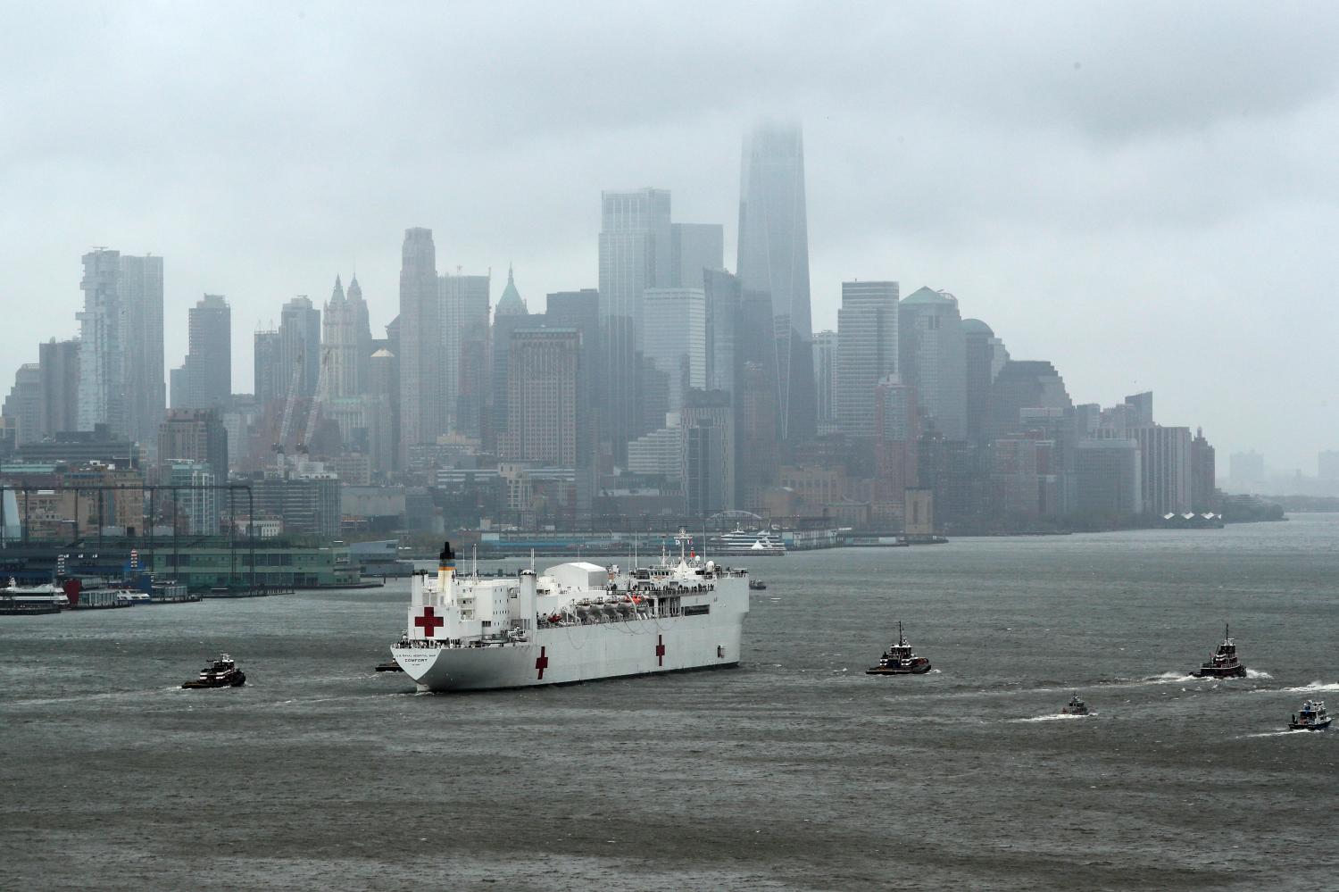 The U.S. Navy hospital ship USNS Comfort heads past lower Manhattan and the World Trade Center building under heavy fog as it leaves to return to its home port of Norfolk, Virginia, after treating patients during the outbreak of coronavirus disease (COVID-19) in New York City New York, U.S., April 30, 2020. REUTERS/Mike Segar