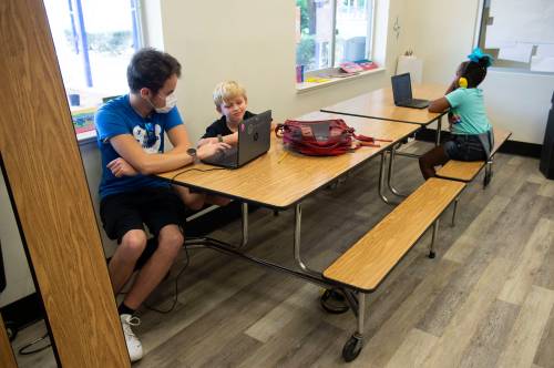Kids attending childcare at the YMCA of the Treasure Coast are keeping distance from each other by sitting apart, including instructor Benjamin Kaufman (left), Brogan Stoecklin, 6, of Jensen Beach, and Messiah Jefferson, 7, of Stuart, on Tuesday, April 28, 2020, at the YMCA campus in Stuart. Because of the effects from the coronavirus pandemic, there has been a 30% decrease in memberships, according to Senior Vice President Charlene Lyons, but locations across the Treasure Coast continue offering childcare services for essential workers who can't stay at home with their children while schools are closed.Tcn Ymca And Covid19