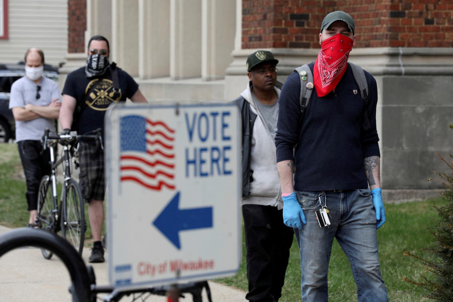 FILE PHOTO: Patrick Kapple, right, waits in line outside Riverside University High School to cast a ballot during the presidential primary election held amid the coronavirus disease (COVID-19) outbreak in Milwaukee, Wisconsin, U.S. April 7, 2020. REUTERS/Daniel Acker